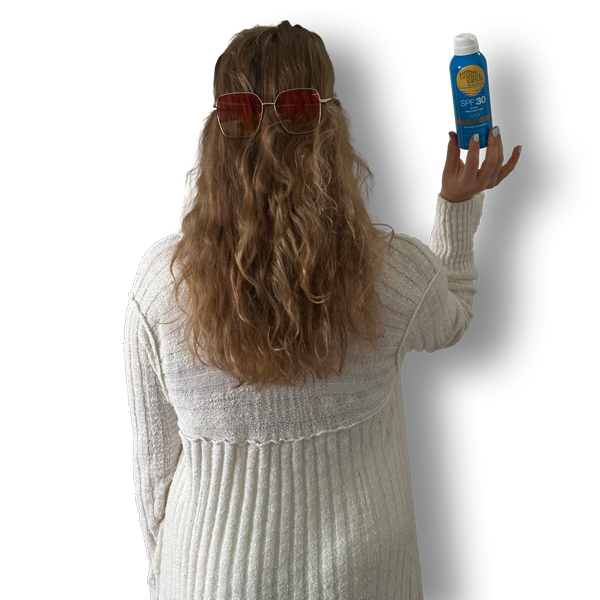 Picture of the back of Nickie wearing sunglasses and holding sun cream